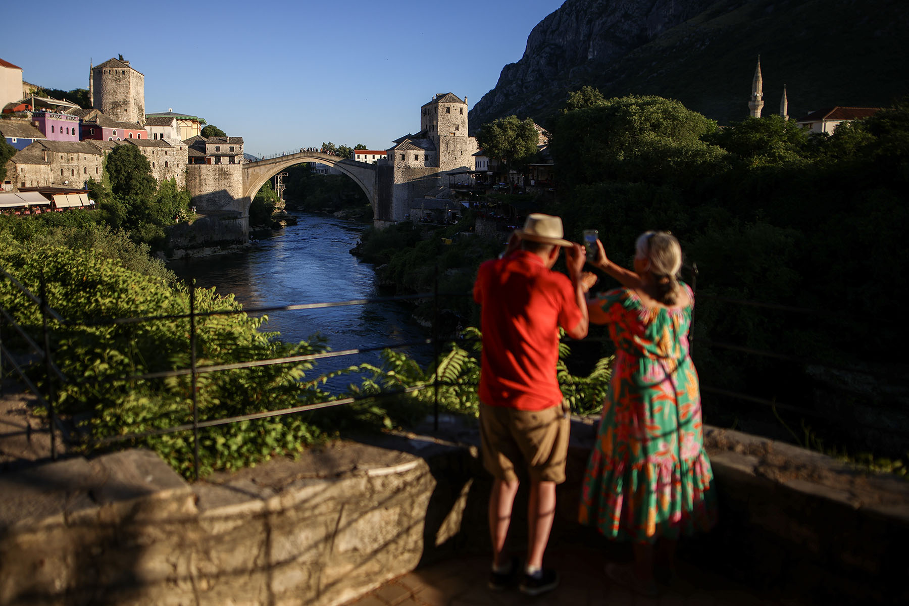 Tourists from the United Kingdom take pictures of the Old Bridge at sunset in Mostar, Bosnia-Herzegovina, this summer. Built in 1566, the Old Bridge was destroyed in the 1992–1995 war, then rebuilt and reopened in 2004.