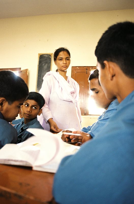 A teacher checks the class work of boys at the Edhi Child Home. Requirements that older students help younger ones help integrate Edhi&#39;s philosophy of self-reliance into the curriculum.&nbsp;