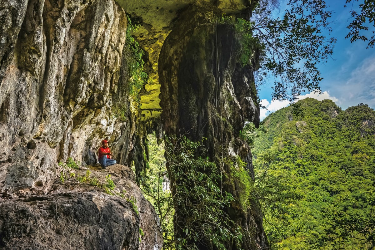 <p>A ledge along the steep trail up the bluff to Leang Sakapao offers a dramatic view of surrounding hills, blocked partially by a massive, trunk-like pillar of limestone. The increase of population and human activity in the region is changing delicate balances of carbon dioxide, moisture and other environmental conditions that have preserved the paintings for so long, lending urgency to further dating work and regional conservation.</p>
