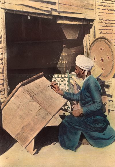 <p>Shown working near the Euphrates River in Iraq in 1922 in this hand-colored photo, a craftsman is decorating a wooden chest. Although demand today is greatly diminished, the tradition of making chests continues, from ornate, handcrafted chests to mass-produced metal boxes.</p>
