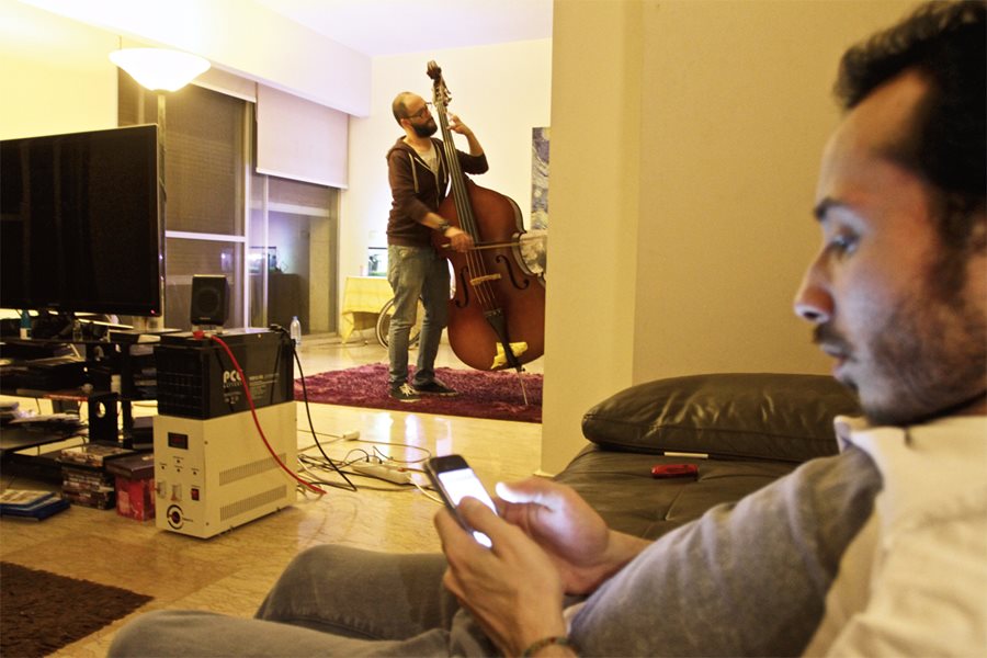 <p>Tanjaret Daghet&#39;s guitarist Khuluki relaxes while Omran practices in the apartment shared by the trio-in-exile: &nbsp;Each band member left a family and friends in Syria. They are now at work on their second album of ferocious guitar, raucous drums and vocals that veer eclectically between boisterous rock-n-roll and soulful <em>mawwal</em>-type chanting.</p>
