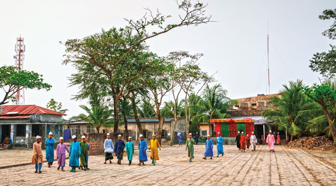 <p>Boys walk through the courtyard of the school in Nalian, where the Shibsa and Sutarkhali rivers converge. </p>