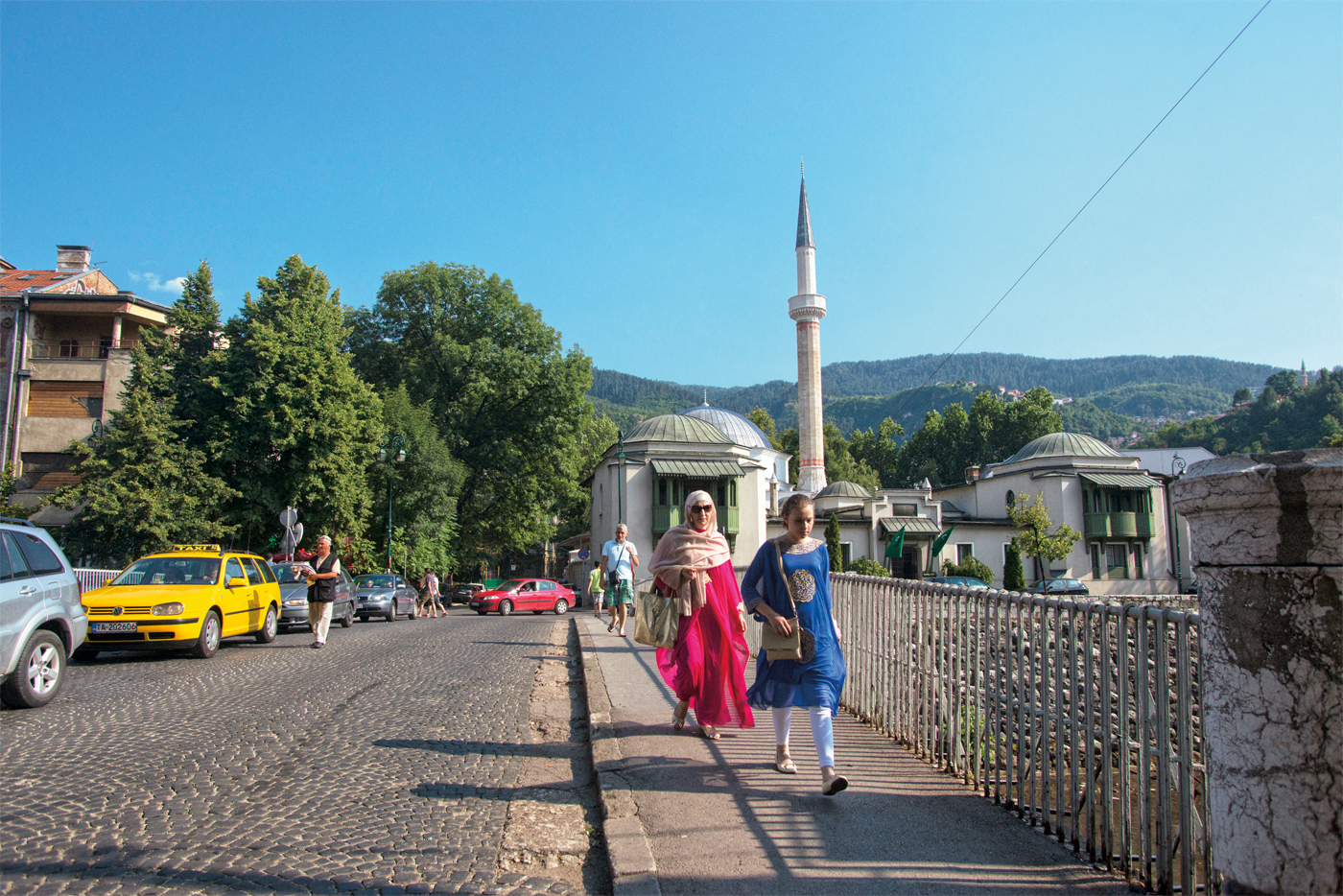 <p>Moradores de Sarajevo caminham pela Ponte do Imperador, a mesma via por onde Jahić e sua equipe passaram sob o ataque de atiradores. A Mesquita do Sultão, lar da biblioteca de 1935 a 1992, pode ser vista ao fundo.</p>
