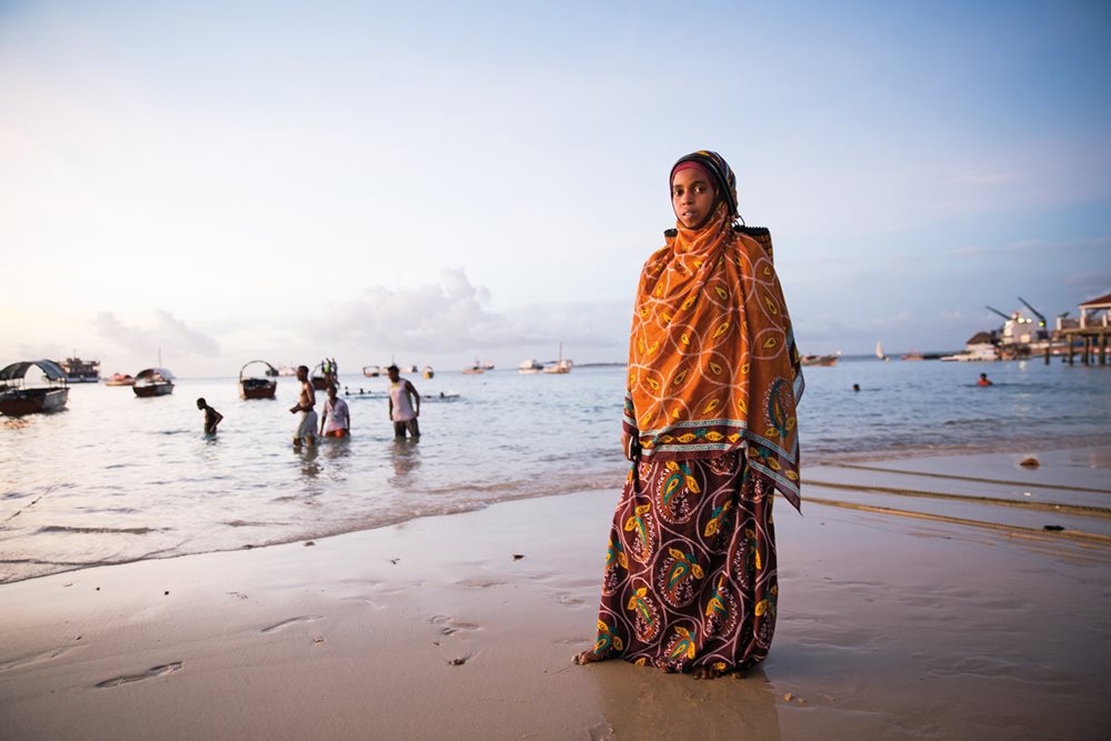 Rabia Omar, a visitor to Zanzibar from the mainland, wears a kanga she purchased in Dar es Salaam, Tanzania, where the demand for kanga is no less than in Zanzibar. The mainland style favors heavier cotton with darker, deeper colors than the Zanzibari style.
