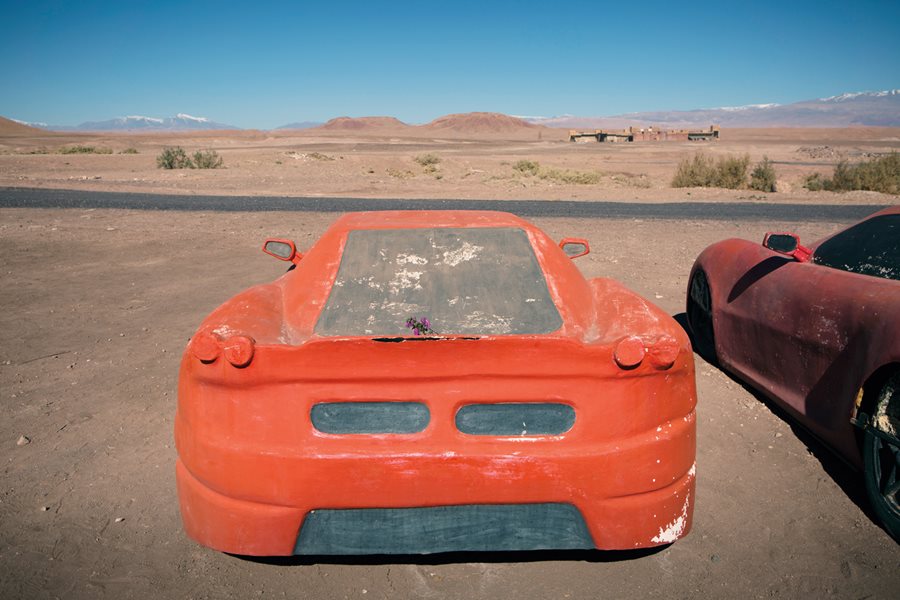 Car props stand in the &ldquo;parking lot&rdquo; at Atlas Studios and, in the distance, the snowcapped High Atlas Mountains decorate the horizon.
