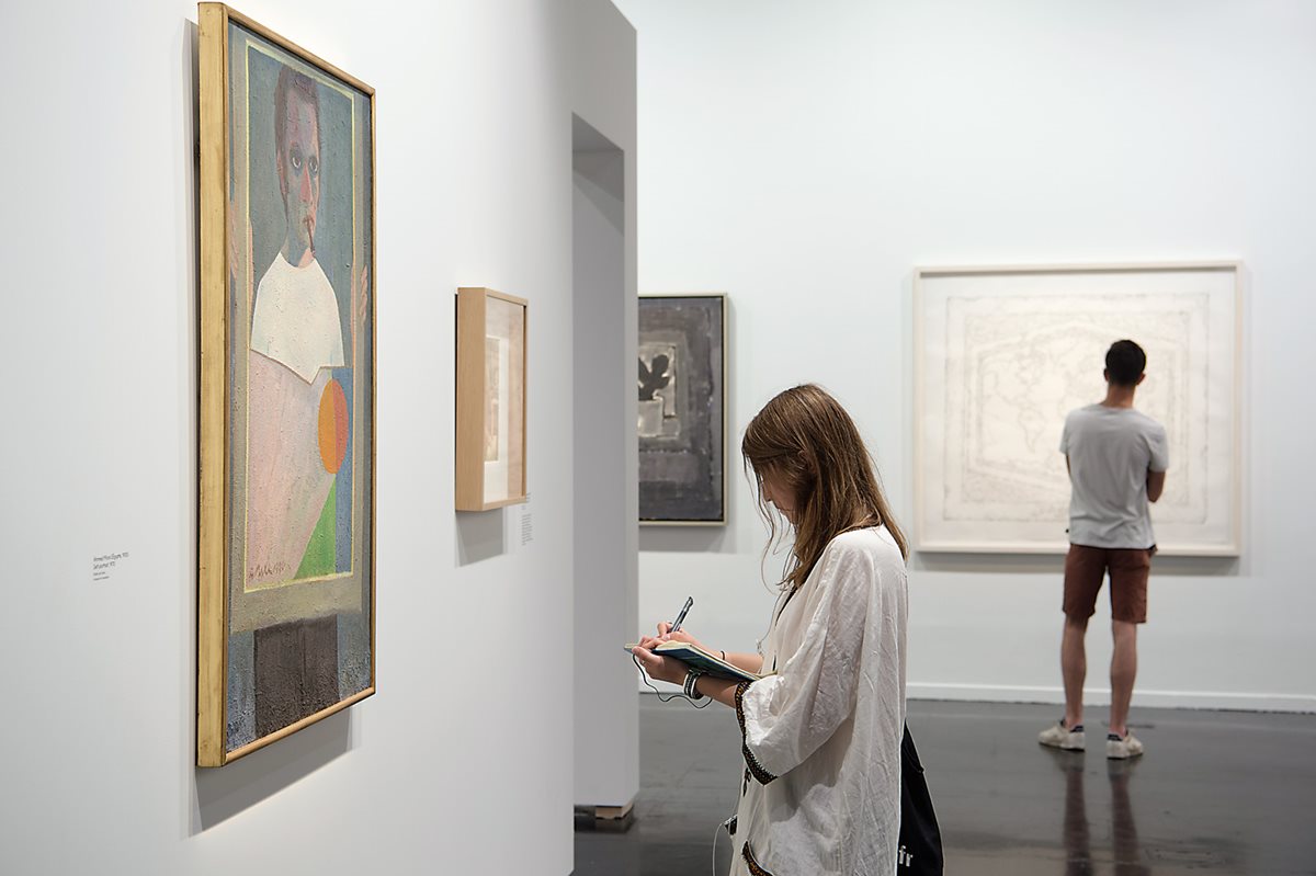 A visitor takes notes in front of Egyptian artist Ahmed Morsi&rsquo;s &ldquo;Self Portrait,&rdquo; painted in 1970 using oil on wood. Through Barjeel, says Arab World Institute President Jack Lang, Al Qassemi is &ldquo;building a collection to benefit art history. It is a major study source, and it promotes better knowledge of the art of the Middle East.&rdquo;