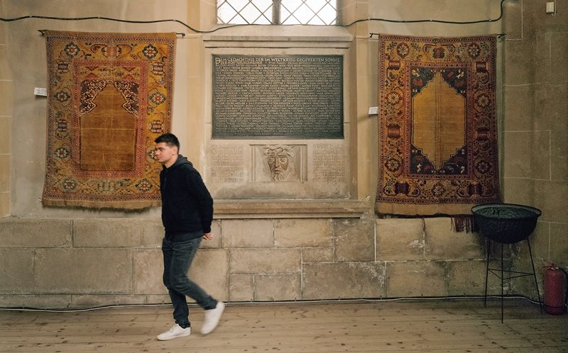 In Braşov&rsquo;s Black Church, a pair of plain-field mihrab carpets, one single-niche and one double-niche, flank a war memorial plaque.&nbsp;