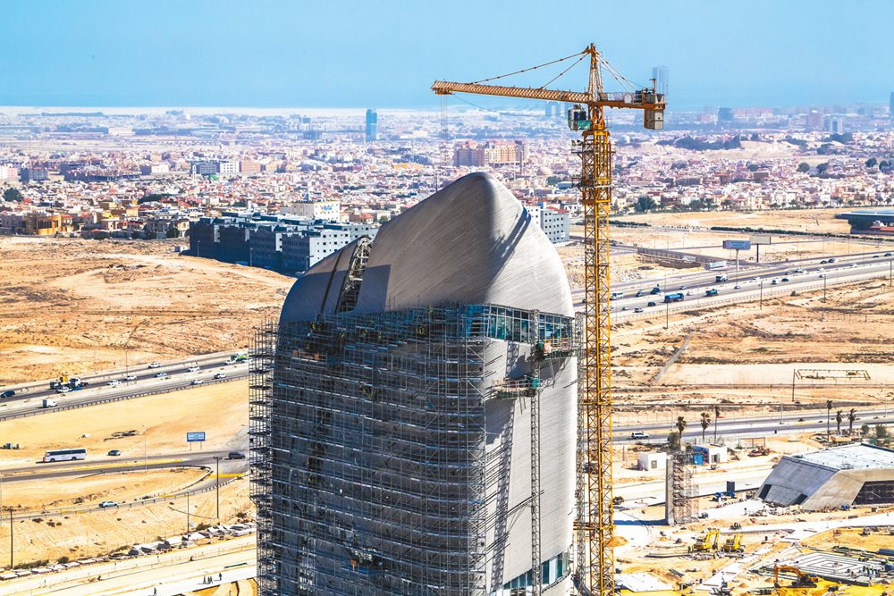 Scaffolding and a crane help workers attach the stainless steel cladding to the top of the Knowledge Tower in 2015. Ithra, Saudi Arabia