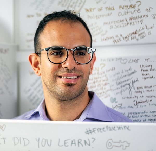 Founder and director Bshara Nassar stands alongside messages from museum visitors. 