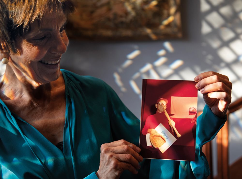 In her San Antonio home, Peggy Karam holds a photo of her late father posing with his bat, glove and hat. Anawaty remained active with the team for many years as a player and, later, a manager.