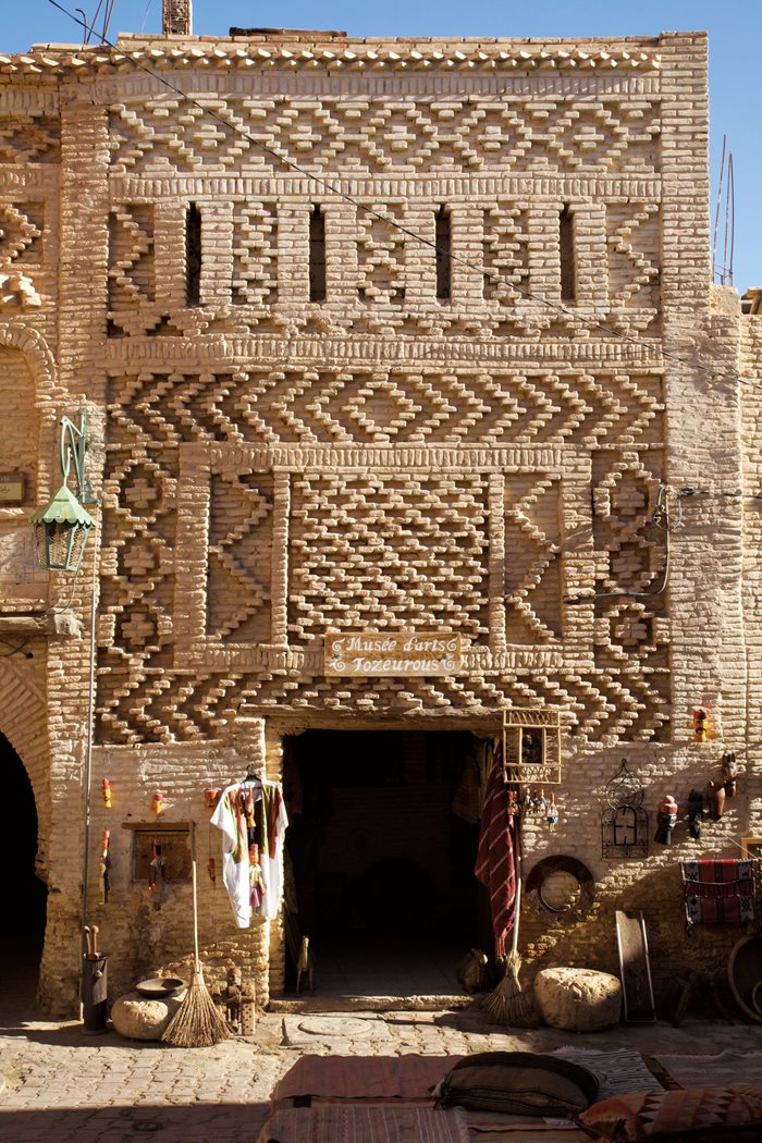 Tozeur’s palmeraie—date palm orchards—grow some 400,000 trees whose regular cuttings fuel the brick kilns. 