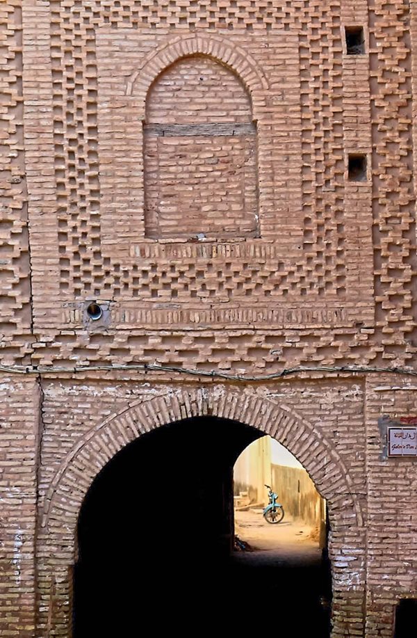 A banded pattern also appears over a vaulted passageway under a house where a central arched window may have once been an opening in the wall, or the window may be a bricklayer’s design device. 