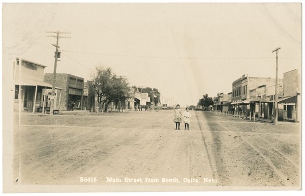  Main Street’s wide and often dusty expanse appears even greater in this card that posed unidentified sisters on it. The street was intersected by others named after places in the Middle East—the only Cairo in the US to do so.