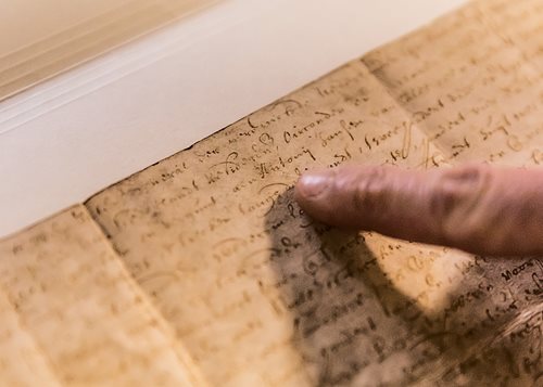 “Anthony van Salee’s land deed is an entry point into essential themes—race, religion, gender and law—that mark Brooklyn’s history across centuries,” says Julie Golia, left, curator for history, social sciences and government at the New York Public Library. This document, signed in 1643 by New Netherland Director General Willem Kieft, affirmed van Salee’s rights to 100 morgens—about 80 hectares—as well as other properties along the south shore of what was then called Breukelen. Under its terms, he paid a portion of his earnings to the Dutch West India Company. Examining the document with Golia are, at center, former Brooklyn Historical Society President Deborah Schwartz and, right, archivist and public historian Maggie Schreiner.