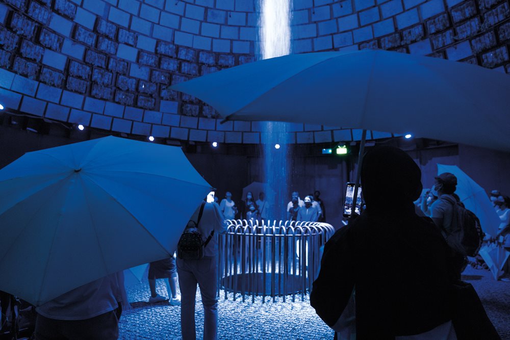 Colored lights enhance the presentation of full-circle water sustainability in the pavilion of The Netherlands, where a self-contained system also irrigated a green cone, right, that grew a variety of plants including tomatoes. 