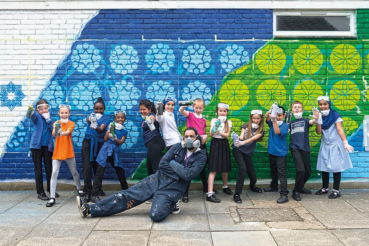 With the mural finished, the Elmhurst School artists pose for a group photo with Teakster. “The arts are for everyone,” he says. “It makes our community stronger.”