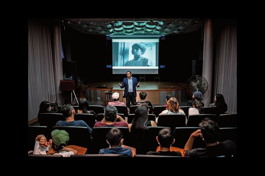 Filmmaker Darwin Yaney Mendoza hosts a screening of Kafati’s first film, Mi Amigo Ángel, in Tegucigalpa, Honduras. The film, which follows a 10-year-old shoeshine boy and was shot in the capital, kept the young audience, below right, engrossed—especially because much of the city looks the same today.