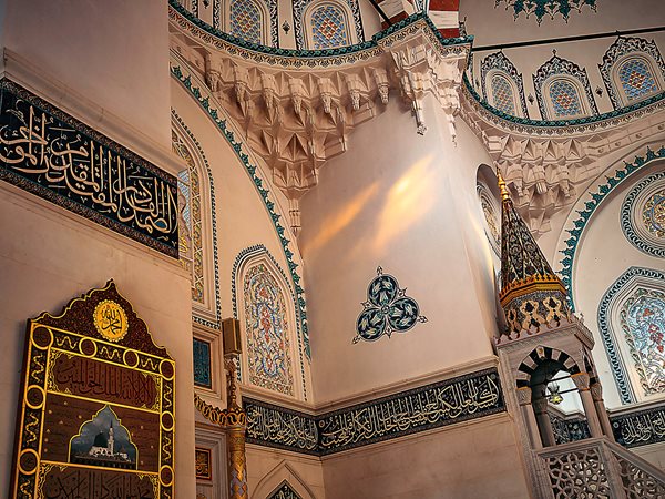 inside the mosque with an ethereal prayer hall of white and turquoise marble detailed in gold.