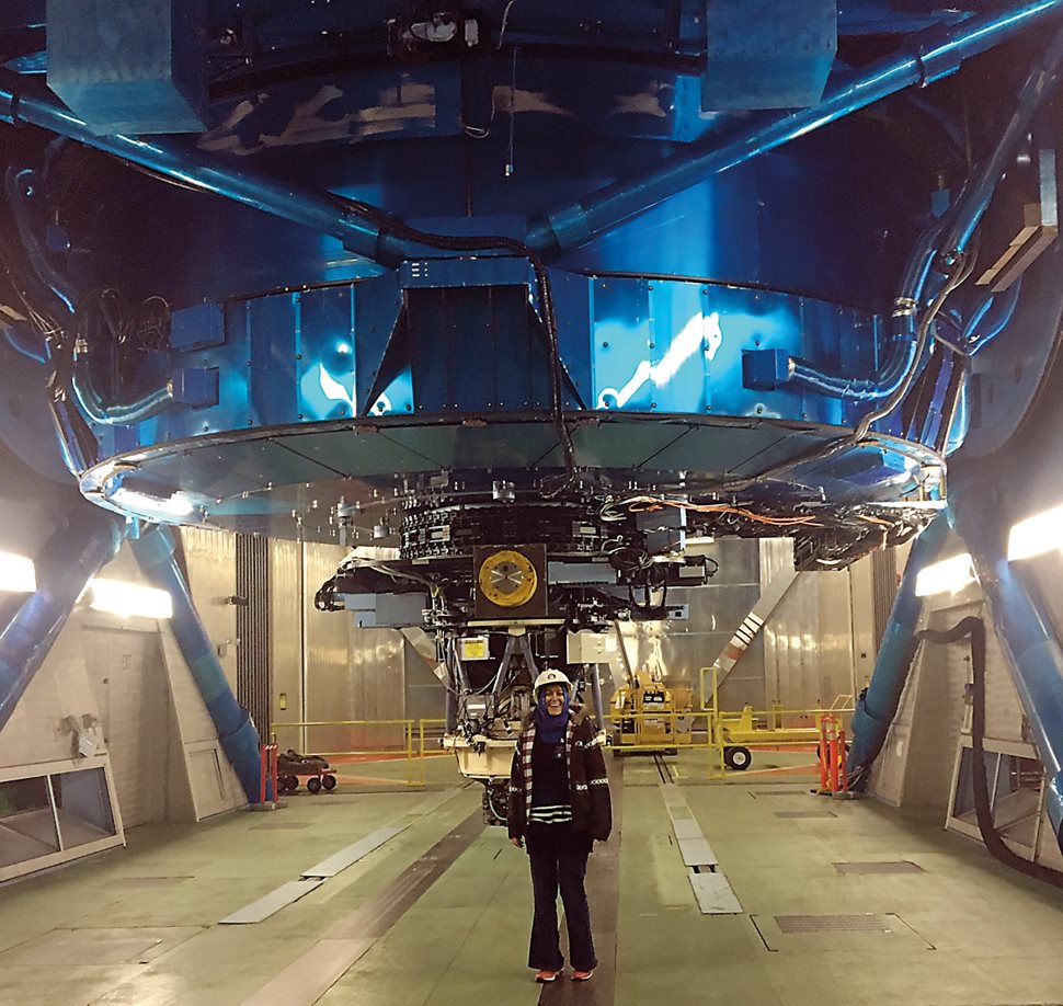 Astrophysicist Burçin Mutlu-Pakdil stands under the 8.2-meter telescope at Maunakea, Hawaii.