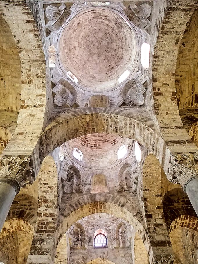 Built meters from Santa Maria dell’Amirraglio and dedicated only nine years later, the vaults and three domes of the church of San Cataldo are devoid of ornament, which makes all the more apparent the Arab-influenced structure—notably the arches as well as the squinches that transition the square vaults up into each round dome. The different capitals on the columns signal reuse of columns from earlier, possibly Roman, structures.