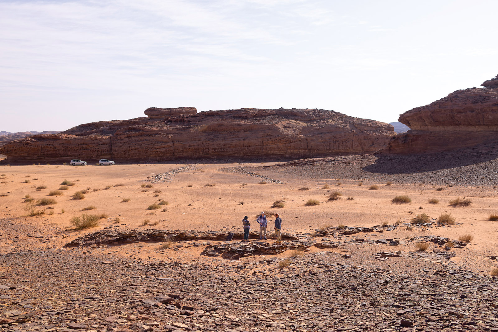 “We believe—this is all hypothetical—that you would have seen various communities or groups of people coming together to build the structure. They would then sacrifice the animals that they had brought with them,” says Kennedy, left, above. Project director Hugh Thomas stands at right and the author at center as they examine one end of the mustatil they are studying.