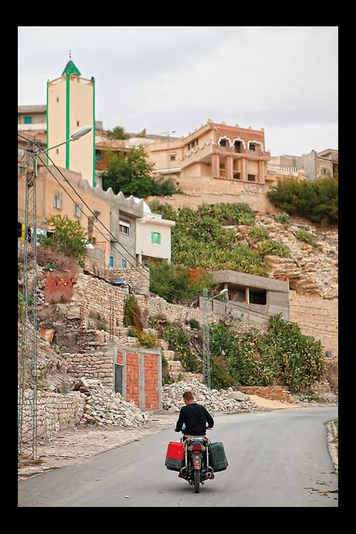 A man carries water on his motorbike from the town spring to vegetable and fig gardens in the village of Kesra. 