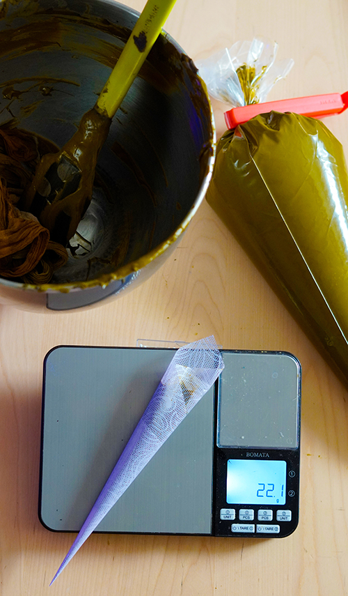 Freshly made henna paste is often strained and dispensed into rolled cellophane sheets and closed with tape. Each henna cone is then carefully weighed and packaged to ensure quality on behalf of the seller. 