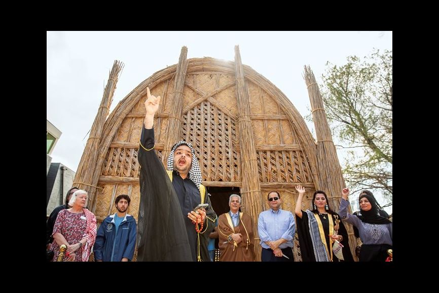 Mohannad Neamah, a Houstonian whose grandfather lived in the marshlands of southern Iraq, recites a poem at the opening of the city’s first and only mudhif. The event celebrates the effort to preserve traditional construction techniques and knowledge in danger of disappearing forever. 