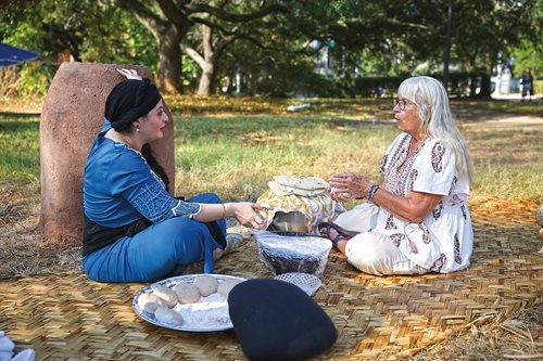 Faten Al Saedi, left, teaches Lynda Werner how to make bread at the event.