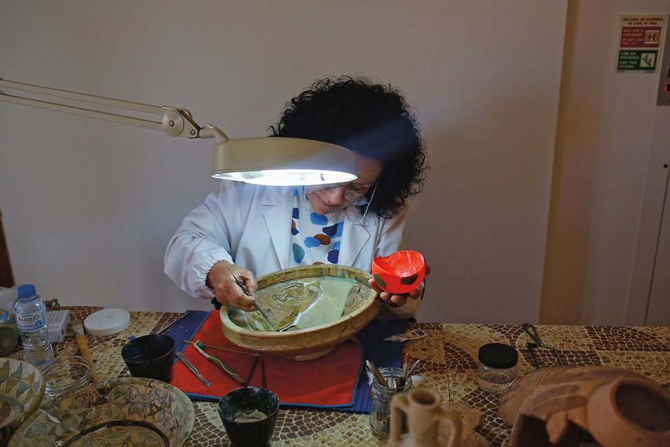 Painstakingly, one small fragment at a time, Guilhermina Bento, a technician for conservation of ceramics, works to restore an Islamic-era bowl at a museum office.