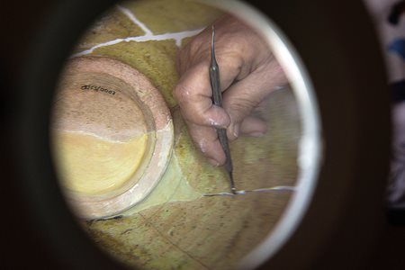 Painstakingly, one small fragment at a time, Guilhermina Bento, a technician for conservation of ceramics, works to restore an Islamic-era bowl at a museum office.