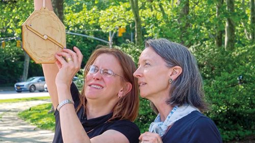 Writer Lee Lawrence, right, guides her stepdaughter, Isa, as she sights along the astrolabe’s alidade to calculate the height of the arch at Grand Army Plaza in Brooklyn, N.Y.